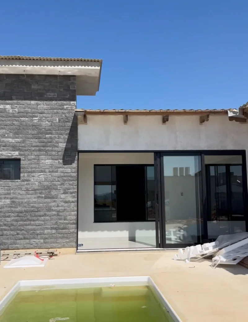 Área de piscina com parede de pedra, obra da WD Engenharia